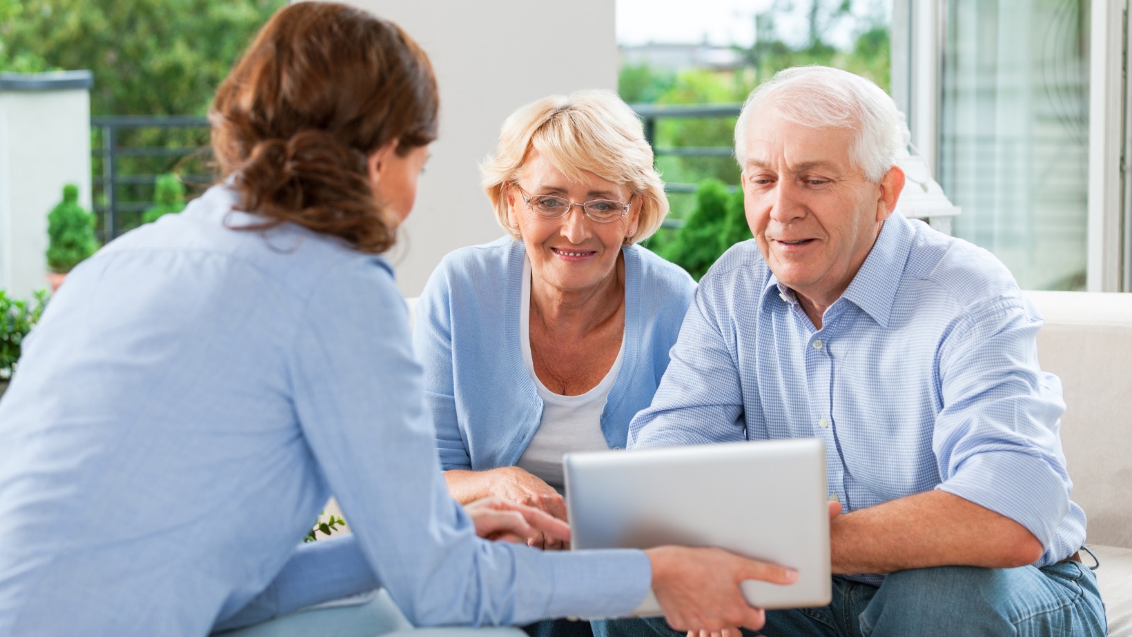 An advisor reviewing Medicare plan options on a tablet with a senior couple